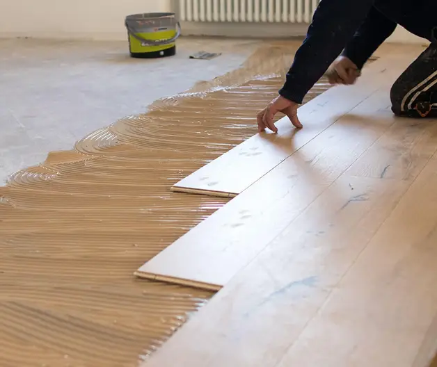A worker installing the wooden flooring