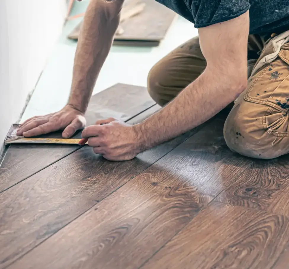 A worker installing the wooden flooring